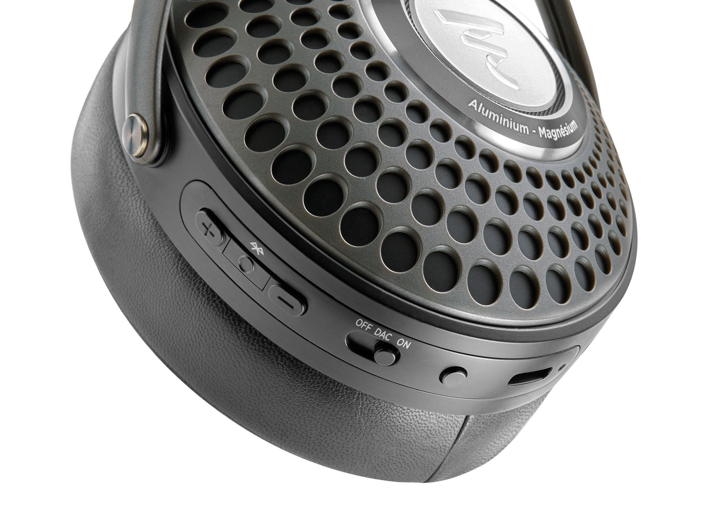 Close-up of a Focal Bathys black over-ear headphone earcup with perforated metal, control buttons, OFF/DAC/ON switch, USB port, and Aluminium - Magnesium labeled on these Focal active noise-canceling headphones.