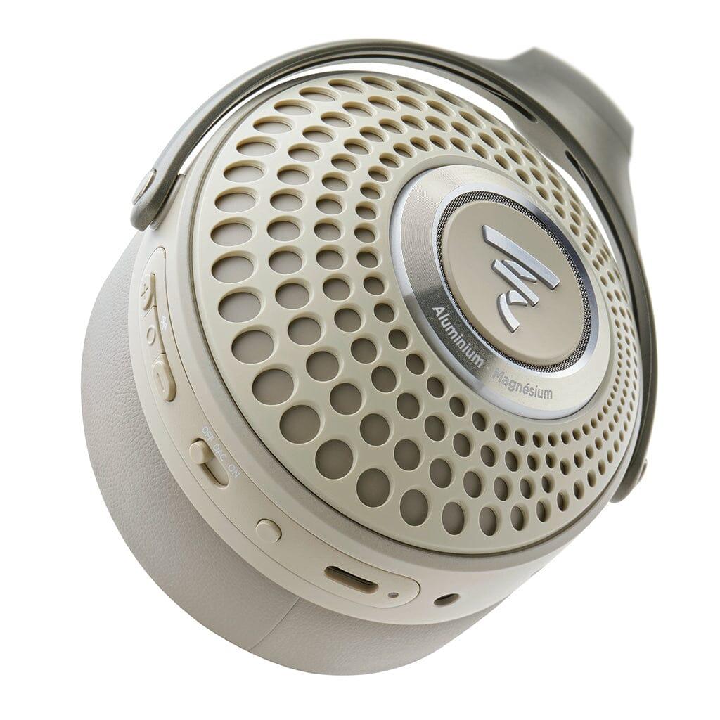 Close-up of a Focal Bathys headphone earcup in beige and silver, featuring a perforated circular grille, metallic center with Focal branding, and side buttons and controls.