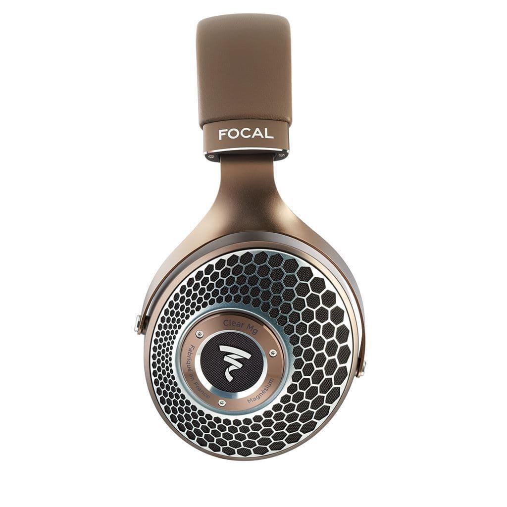 A close-up of the Focal Clear Mg Headphones by Focal displays the brown ear cup with a honeycomb-pattern grille and the Focal logo, all set against a plain white background.