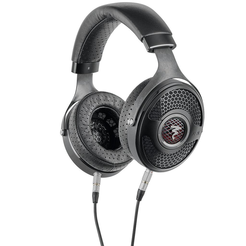The Focal Utopia 2022 headphones feature black cushioned ear pads, a perforated headband, and silver honeycomb grilles. Detachable audio cables connect to both ear cups for exceptional sound quality.