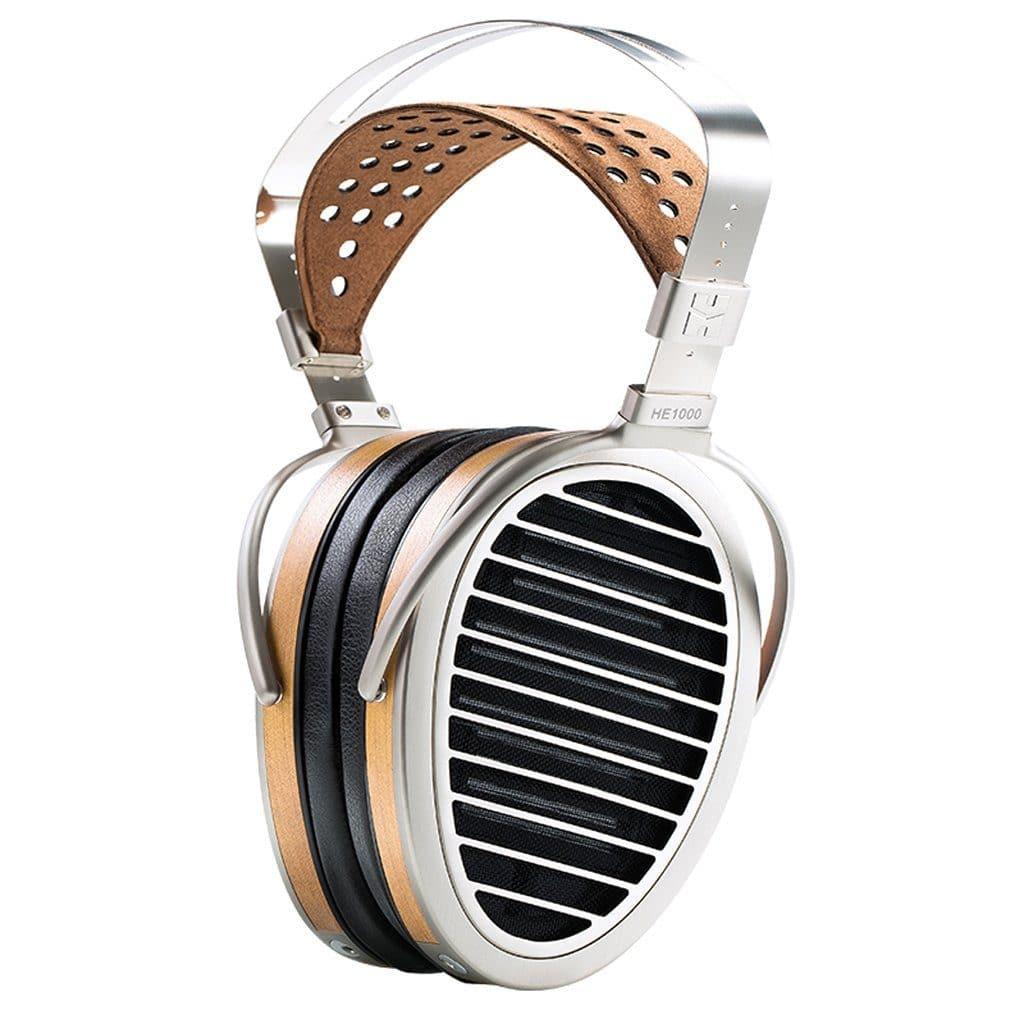 Experience premium sound with Hifiman HE1000 V4 Stealth Magnet Edition headphones, featuring large oval earcups with black horizontal grills, a silver metal frame, and a tan perforated leather headband.